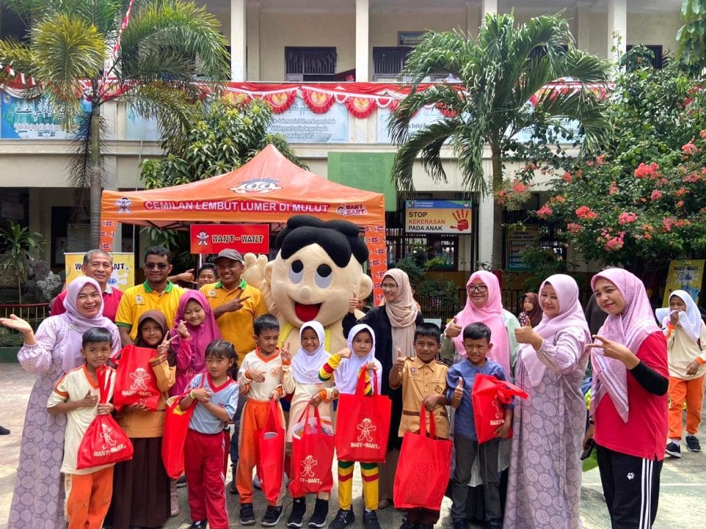 SPG melakukan sampling selling O’Pao kepada murid sekolah di Indonesia