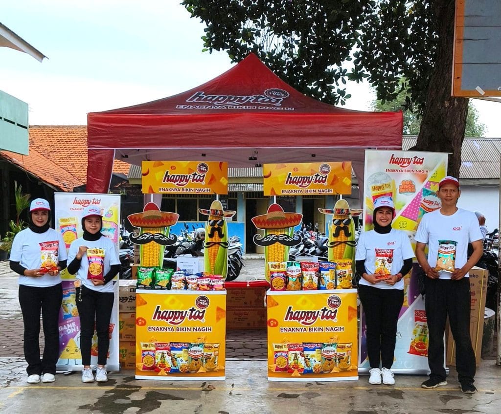 Pembagian sampel Happy Tos kepada murid sekolah oleh SPG
