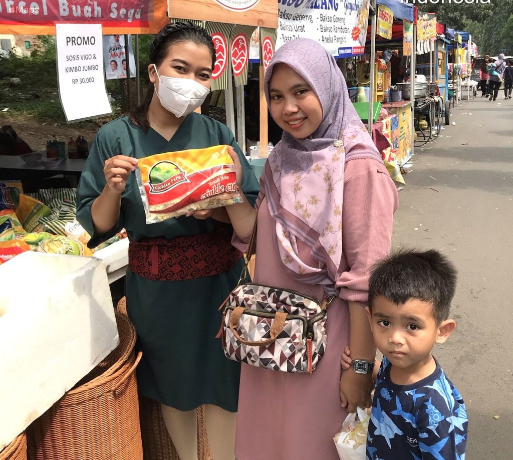 SPG menawarkan produk frozen food kepada pengunjung pasar pagi