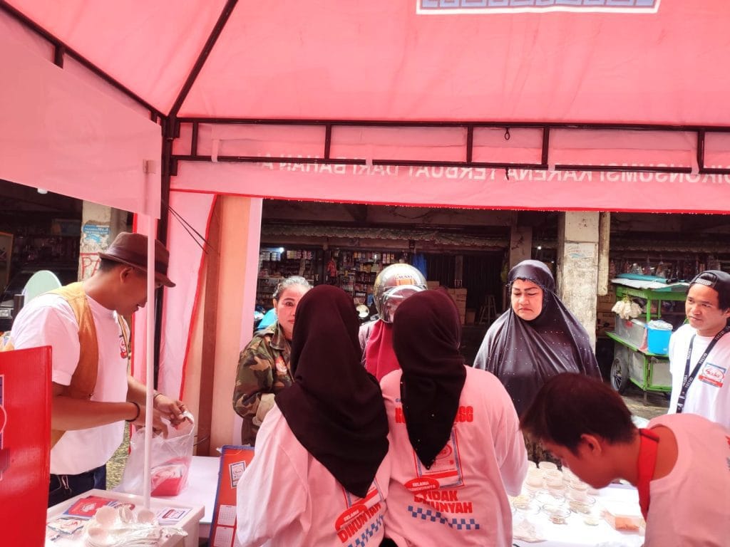 SPG Sasa MSG menawarkan produk kepada pengunjung pasar