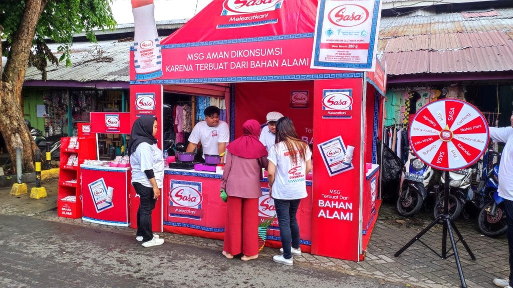 SPG Sasa MSG membagikan sampel produk kepada pengunjung pasar