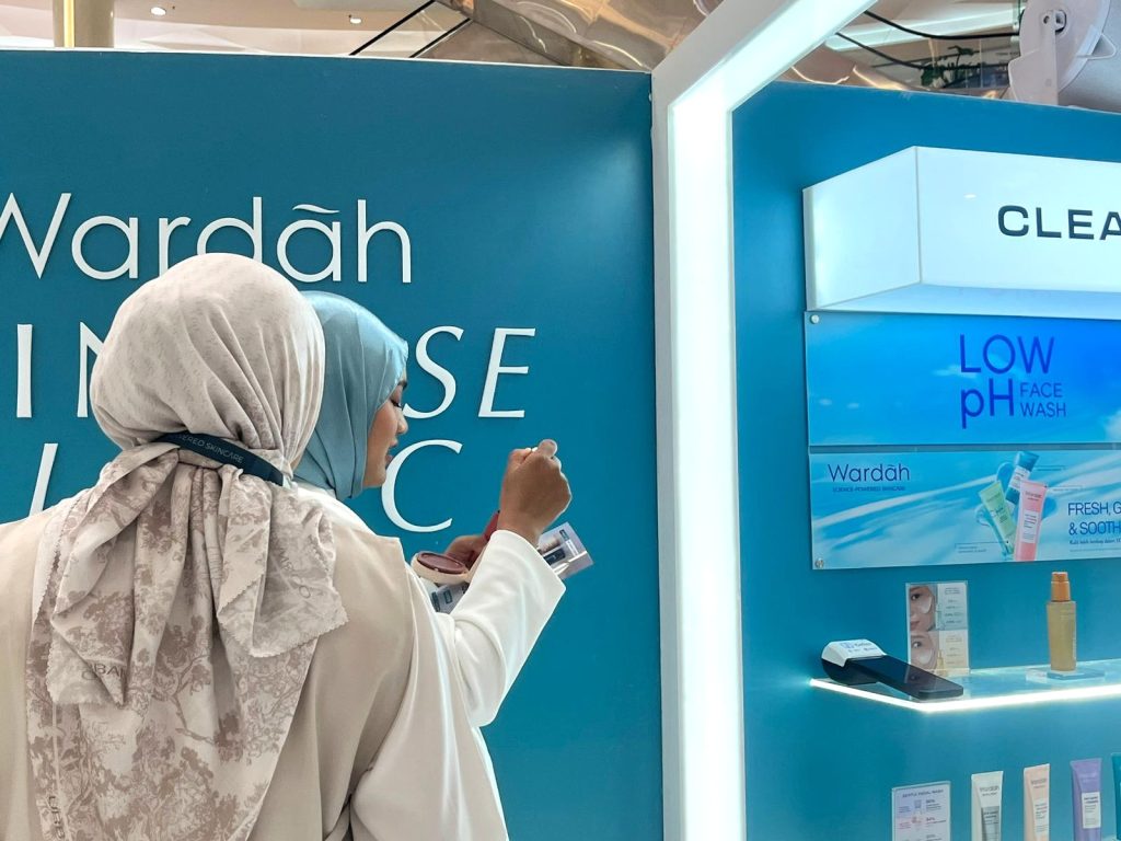 Beauty advisor Wardah membantu pengunjung melakukan AI skin check