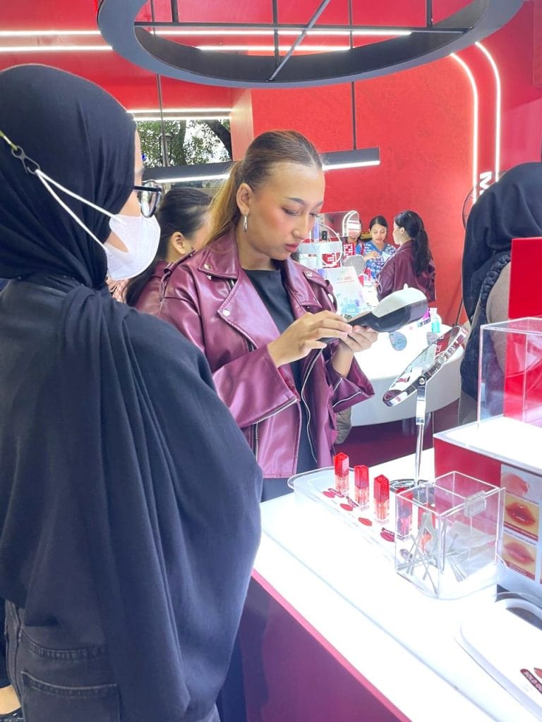 Beauty advisor memberikan makeover experience di booth activation OMG Beauty